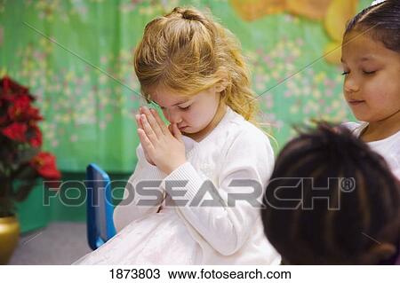 a young girl bowing her head in prayer View Large Photo Image Stock Image - a young girl bowing her head in prayer. Fotosearch