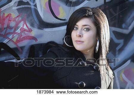 a young woman against a wall with graffiti View Large Photo Image Picture - a young woman against a wall with graffiti. Fotosearch