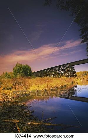 Picture - alberta, canada; a train trestle and a beaver dam in the river below. Fotosearch