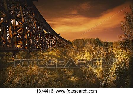 Stock Photograph - alberta, canada; a train trestle in a sunset. Fotosearch