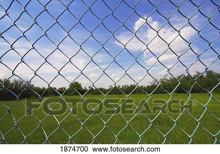 Stock Image - alberta, canada; looking at the sky through a chain link fence. Fotosearch
