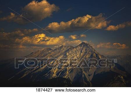 Stock Photo - banff, alberta, canada; a snow covered mountain under clouds in the sky. Fotosearch