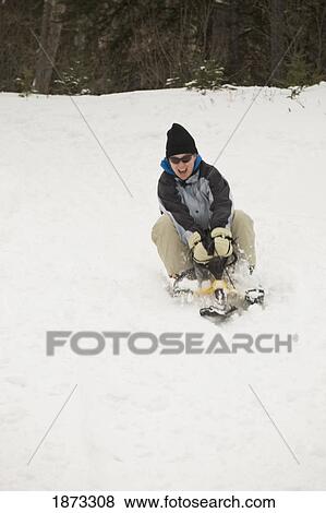 Stock Photo - blairmore, alberta, canada; a female sledding down a hill. Fotosearch