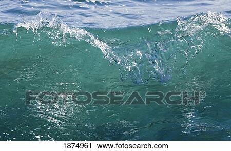 Stock Image - clear sea water as a wave begins to break. Fotosearch