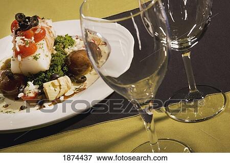 Stock Photo - edmonton, alberta, canada; a dinner on a plate and two wine glasses. Fotosearch