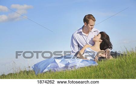 edmonton, alberta, canada; a man and woman laying on the grass together View Large Photo Image Stock Image - edmonton, alberta, canada; a man and woman laying on the grass together. Fotosearch