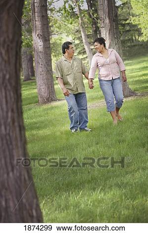 edmonton, alberta, canada; a man and woman walking through a park holding hands View Large Photo Image Stock Photo - edmonton, alberta, canada; a man and woman walking through a park holding hands. Fotosearch