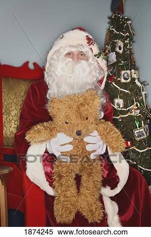 Stock Photography - edmonton, alberta, canada; santa claus holding a teddy bear. Fotosearch