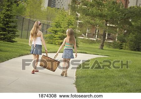 edmonton, alberta, canada; two girls carrying a picnic basket down the sidewalk View Large Photo Image Stock Photo - edmonton, alberta, canada; two girls carrying a picnic basket down the sidewalk. Fotosearch
