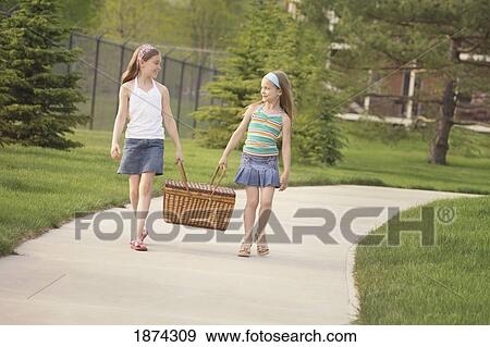 edmonton, alberta, canada; two girls carrying a picnic basket down the sidewalk View Large Photo Image Stock Photo - edmonton, alberta, canada; two girls carrying a picnic basket down the sidewalk. Fotosearch