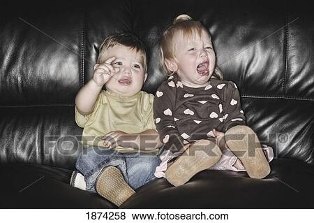 edmonton, alberta, canada; two young children sitting on the couch together and crying View Large Photo Image Stock Photo - edmonton, alberta, canada; two young children sitting on the couch together and crying. Fotosearch