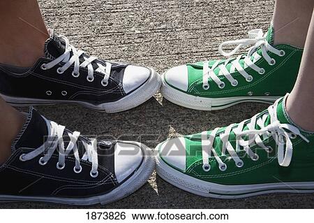 Stock Photograph - feet inside two pairs of lace up shoes. Fotosearch