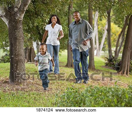 fort lauderdale, florida, united states of america; a mother and father chasing their young son through a park View Large Photo Image Picture - fort lauderdale, florida, united states of america; a mother and father chasing their young son through a park. Fotosearch