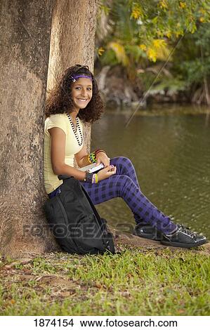 fort lauderdale, florida, united states of america; a girl reading a book under a tree View Large Photo Image Picture - fort lauderdale, florida, united states of america; a girl reading a book under a tree. Fotosearch