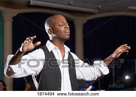 Picture - fort lauderdale, florida, united states of america; a man with his hands raised in worship. Fotosearch