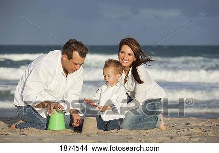 Picture - fort lauderdale, florida, united states of america; a family playing in the sand on the beach. Fotosearch