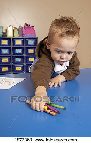 fort lauderdale, florida, united states of america; a young boy reaching for crayons on a table in a classroom View Large Photo Image Stock Image - fort lauderdale, florida, united states of america; a young boy reaching for crayons on a table in a classroom. Fotosearch