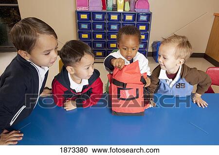 fort lauderdale, florida, united states of america; four young boys sitting at a table in a classroom looking into a lunch bag View Large Photo Image Stock Image - fort lauderdale, florida, united states of america; four young boys sitting at a table in a classroom looking into a lunch bag. Fotosearch