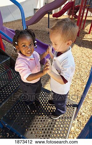 Stock Image - fort lauderdale, florida, united states of america; two young children playing at a playground. Fotosearch