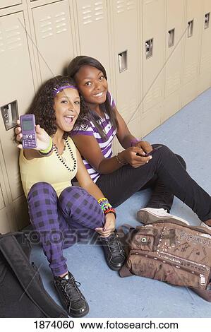 fort lauderdale, florida, united states of america; two teenage girls in the school hallway using their cell phones View Large Photo Image Stock Image - fort lauderdale, florida, united states of america; two teenage girls in the school hallway using their cell phones. Fotosearch