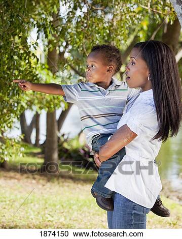 Stock Image - fort lauderdale, florida, united states of america; a mother holding her young son as he points to something. Fotosearch