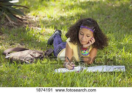 fort lauderdale, florida, united states of america; a teenage girl laying on the grass in a park doing school work View Large Photo Image Stock Image - fort lauderdale, florida, united states of america; a teenage girl laying on the grass in a park doing school work. Fotosearch