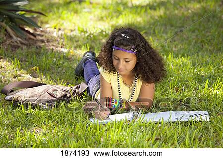fort lauderdale, florida, united states of america; a teenage girl laying on the grass in the park doing school work View Large Photo Image Stock Image - fort lauderdale, florida, united states of america; a teenage girl laying on the grass in the park doing school work. Fotosearch