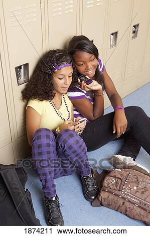fort lauderdale, florida, united states of america; two teenage girls using their cell phones while sitting in the school hallway View Large Photo Image Stock Image - fort lauderdale, florida, united states of america; two teenage girls using their cell phones while sitting in the school hallway. Fotosearch