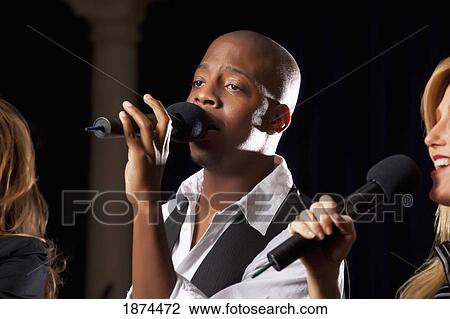 fort lauderdale, florida, united states of america; a man singing into a microphone along with two women View Large Photo Image Stock Image - fort lauderdale, florida, united states of america; a man singing into a microphone along with two women. Fotosearch