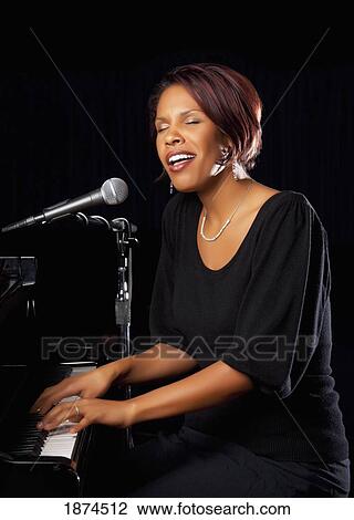 fort lauderdale, florida, united states of america; a woman playing the piano and singing into a microphone View Large Photo Image Stock Image - fort lauderdale, florida, united states of america; a woman playing the piano and singing into a microphone. Fotosearch