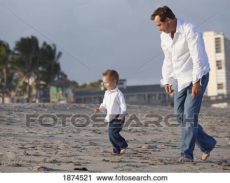 Stock Image - fort lauderdale, florida, united states of america; a father walking on the beach with his son. Fotosearch
