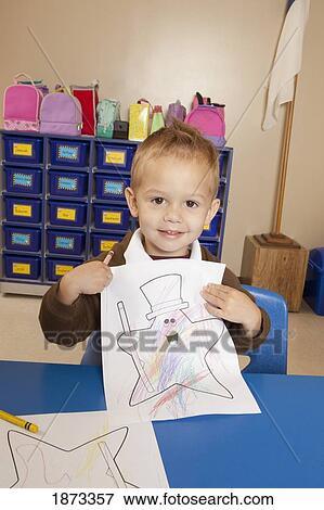 fort lauderdale, florida, united states of america; a young boy showing his coloring sheet and sitting at a table in a classroom View Large Photo Image Stock Photo - fort lauderdale, florida, united states of america; a young boy showing his coloring sheet and sitting at a table in a classroom. Fotosearch
