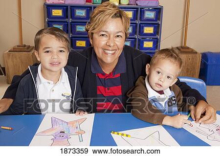 Stock Photo - fort lauderdale, florida, united states of america; a teacher with two young boys at a table in a classroom. Fotosearch
