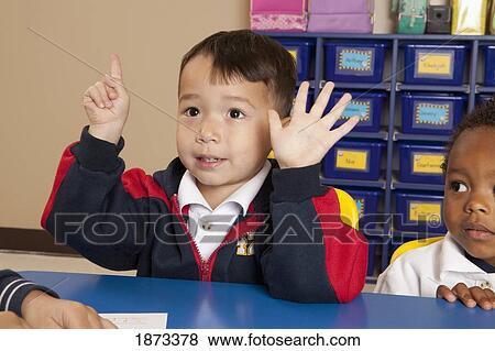 Stock Photo - fort lauderdale, florida, united states of america; a young boy holding up six fingers at a table in a classroom. Fotosearch