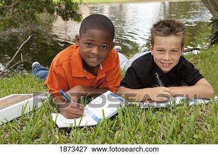 Stock Photo - fort lauderdale, florida, united states of america; two boys doing school work in the park. Fotosearch