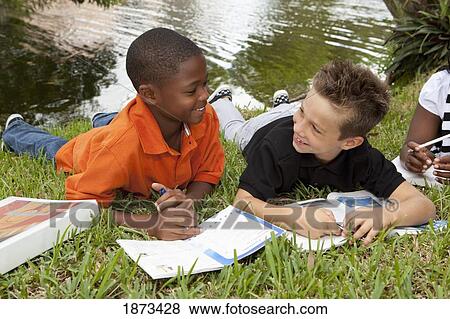 Stock Photo - fort lauderdale, florida, united states of america; two boys doing school work in the park. Fotosearch