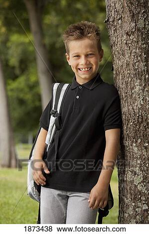 fort lauderdale, florida, united states of america; a boy with his backpack standing beside a tree in the park View Large Photo Image Stock Photo - fort lauderdale, florida, united states of america; a boy with his backpack standing beside a tree in the park. Fotosearch