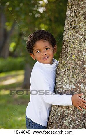 Stock Photo - fort lauderdale, florida, united states of america; a young boy by a tree in a park. Fotosearch