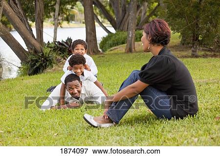 fort lauderdale, florida, united states of america; sons piling on their father's back while their mother watches View Large Photo Image Stock Photo - fort lauderdale, florida, united states of america; sons piling on their father's back while their mother watches. Fotosearch