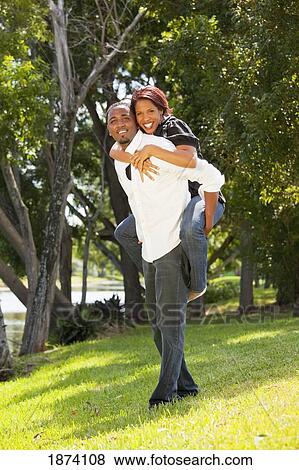 Stock Photo - fort lauderdale, florida, united states of america; a man holding a woman on his back. Fotosearch