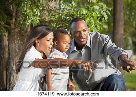 Stock Photo - fort lauderdale, florida, united states of america; a mother and father pointing to something for their young son to see. Fotosearch