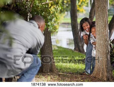 fort lauderdale, florida, united states of america; a mother and father playing with their young son behind trees in a park View Large Photo Image Stock Photo - fort lauderdale, florida, united states of america; a mother and father playing with their young son behind trees in a park. Fotosearch