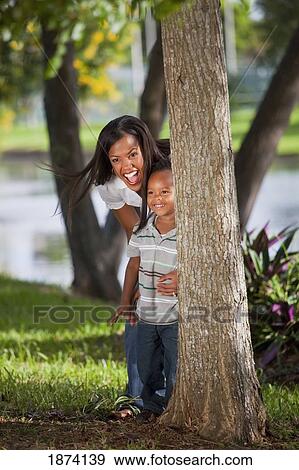 fort lauderdale, florida, united states of america; a mother and young son hiding behind a tree in a park View Large Photo Image Stock Photo - fort lauderdale, florida, united states of america; a mother and young son hiding behind a tree in a park. Fotosearch