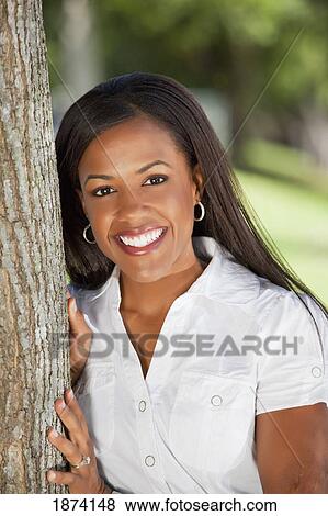 Stock Photo - fort lauderdale, florida, united states of america; a woman leaning against a tree. Fotosearch