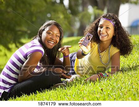 Stock Photo - fort lauderdale, florida, united states of america; two teenage girls showing a picture of themselves on a cell phone. Fotosearch