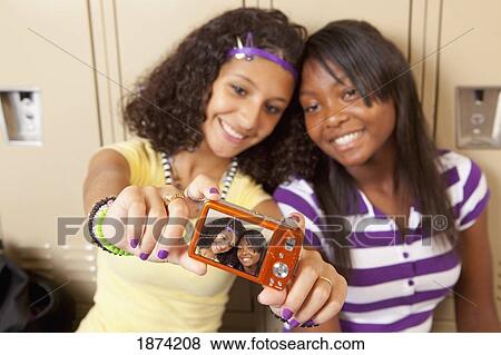 fort lauderdale, florida, united states of america; two teenage girls sitting in a school hallway taking a picture of themselves View Large Photo Image Stock Photo - fort lauderdale, florida, united states of america; two teenage girls sitting in a school hallway taking a picture of themselves. Fotosearch