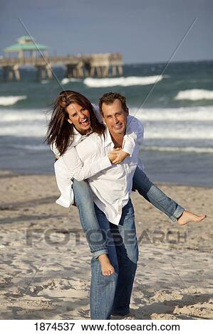Stock Photo - fort lauderdale, florida, united states of america; a couple having fun on the beach. Fotosearch