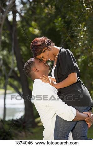 Stock Photograph - fort lauderdale, florida, united states of america; a couple in an embrace in a park. Fotosearch