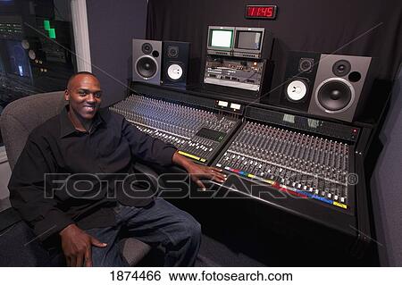 Stock Photograph - fort lauderdale, florida, united states of america; a man sitting at the sound board in a recording studio. Fotosearch