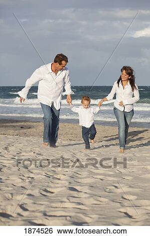 Stock Photograph - fort lauderdale, florida, united states of america; a family running on the beach. Fotosearch